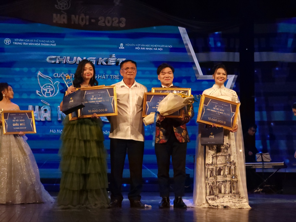Nhạc sĩ Bá Môn trao giải Bài hát về Hà nội hay nhất và chụp ảnh cùng 3 thí sinh đoạt giải nhất.cuộc thi.